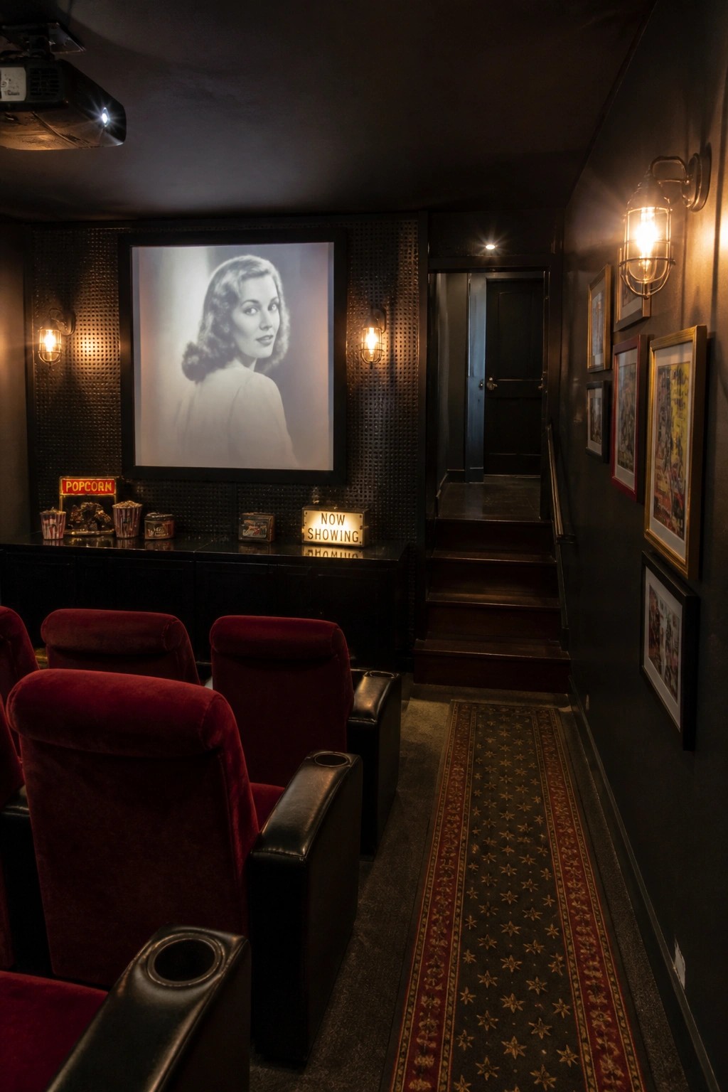 A dimly lit home theater with black walls, red velvet seats, a projection screen showing a black and white portrait of a woman, and a ceiling-mounted projector.