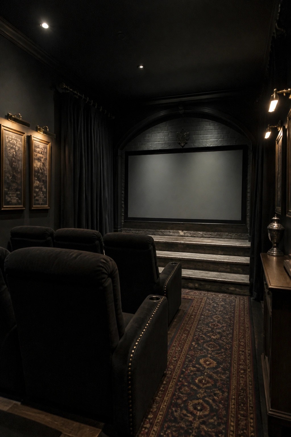 Dark home theater with black velvet seats, large screen, patterned rug, and dim sconces.